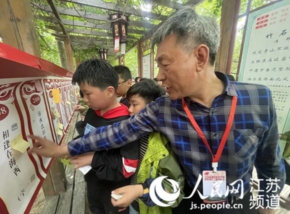 图为“谜人”指导学生猜灯谜。灌南县党史学习教育领导小组办公室供图