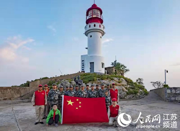 守岛民兵、少先队员代表等与国旗合影。灌云县委宣传部供图