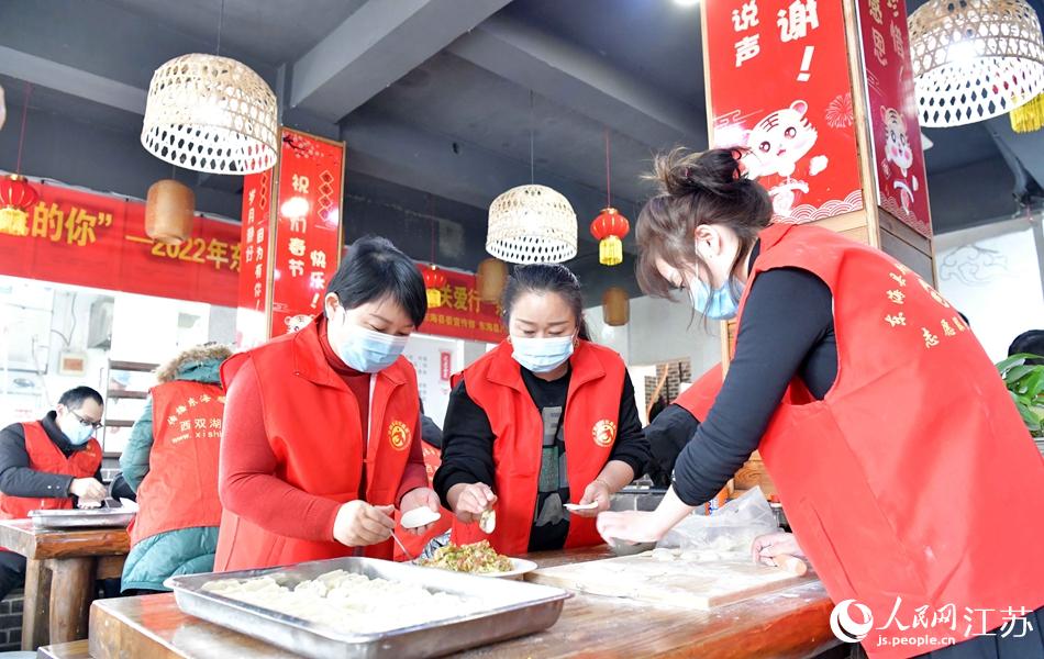 志願者和餃子店員工一起為環衛工人包餃子。張開虎攝