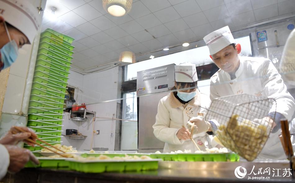 餃子店員工為未能進店的環衛工人打包餃子。張開虎攝