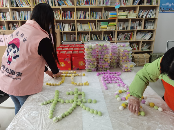 高淳“淳爱姐姐”巾帼志愿者将包好的元宵摆成“元宵快乐”字样。刘雯摄