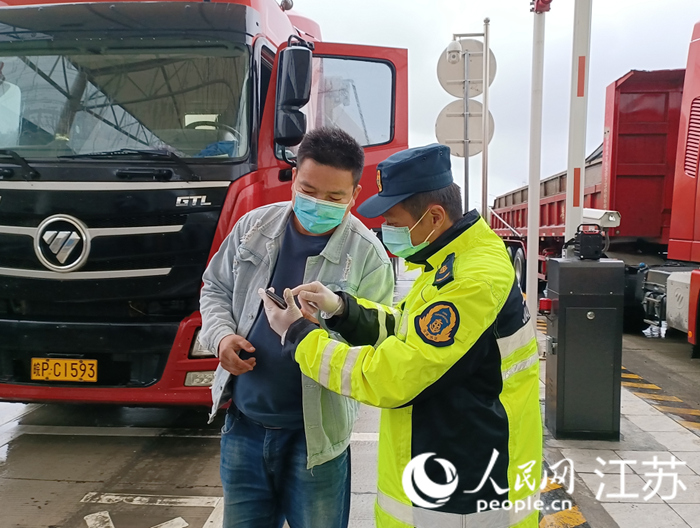 现场交通执法人员向外地驾乘人员耐心解答政策，核对相关信息。 宋端平摄