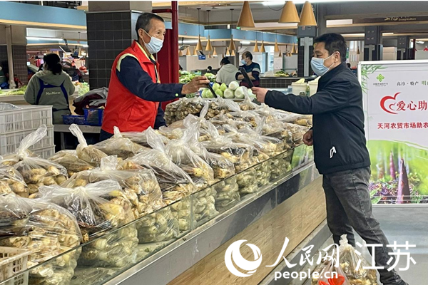 高淳区天河农贸市场助农摊位上，市民正在支付刚刚购买的农产品。陈明洋摄