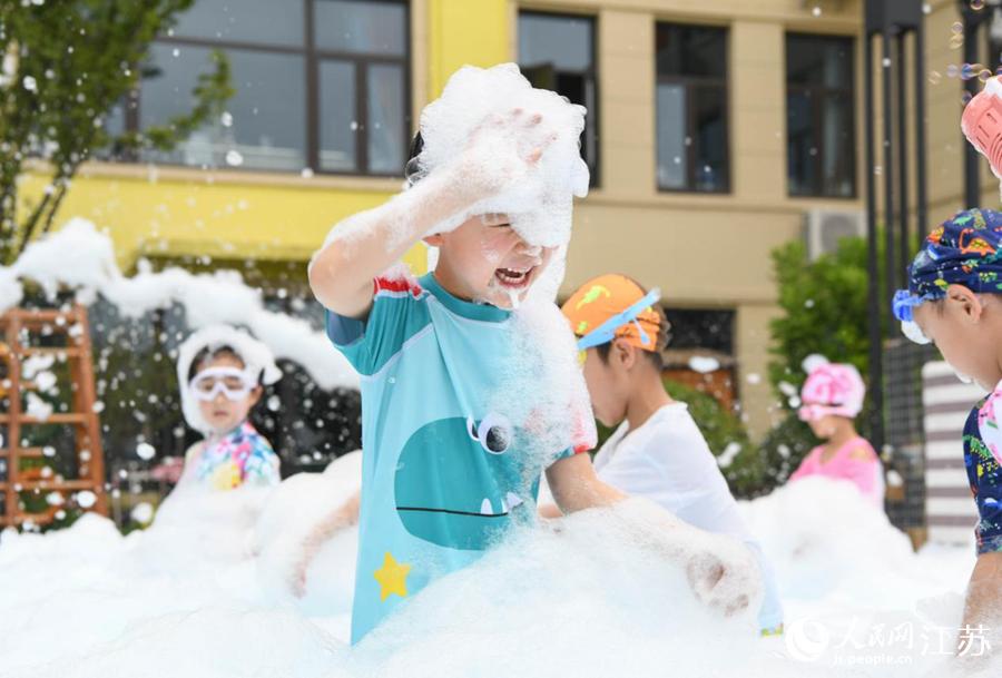 新城幼儿园的孩子们在泡沫中嬉戏打闹。胡润摄