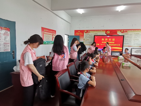 志愿者为新港村低收入家庭儿童赠送助学金和学习用品。高淳烟草供图