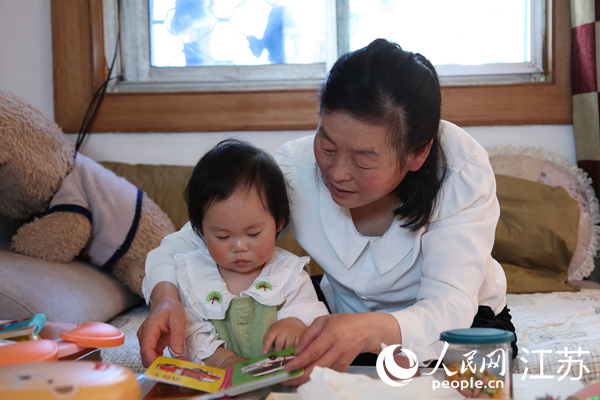 王继莲带孙女看童书。人民网 冷金明摄