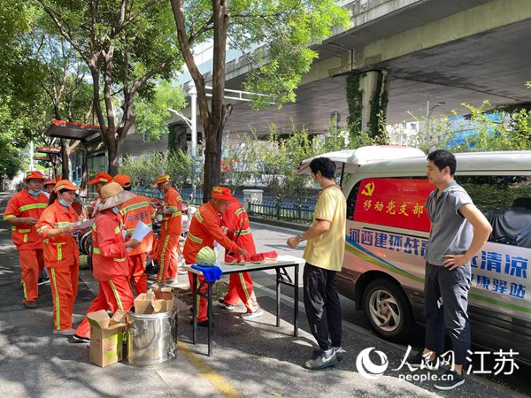 南京市建邺区通过移动“安康驿站”为环卫工送来冰棍、西瓜等防暑降温物资。人民网 李子佩摄