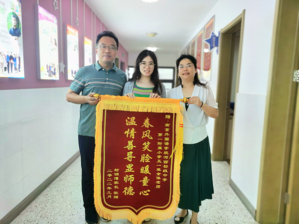  孩子转学后成绩有了较大进步，今年9月，姜坤琴向老师们送上锦旗。建宣摄