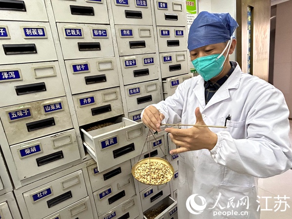 药师在药柜间抓药、称重。人民网 顾姝姝摄