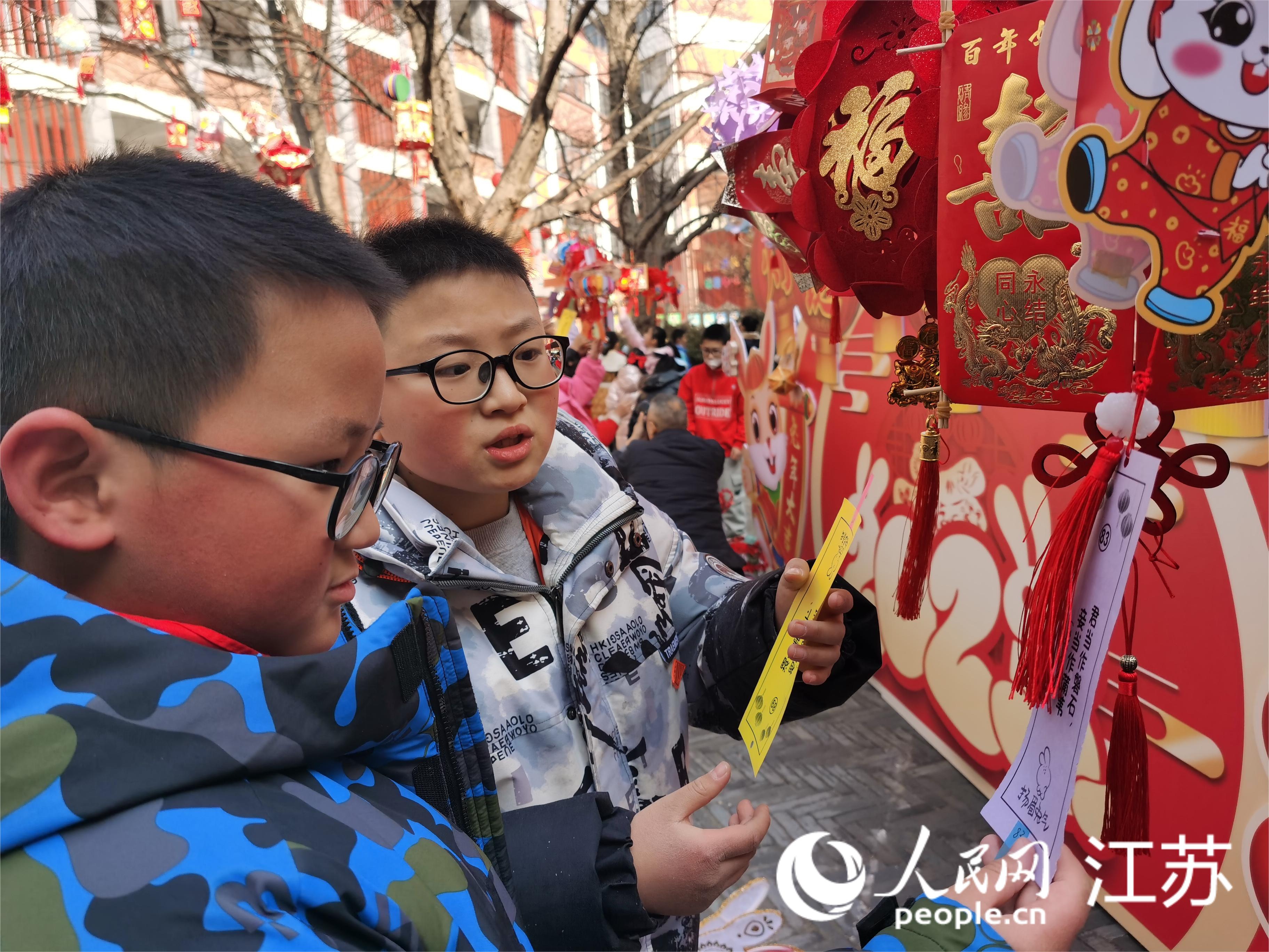 孩子们正在猜灯谜。人民网记者王继亮摄 