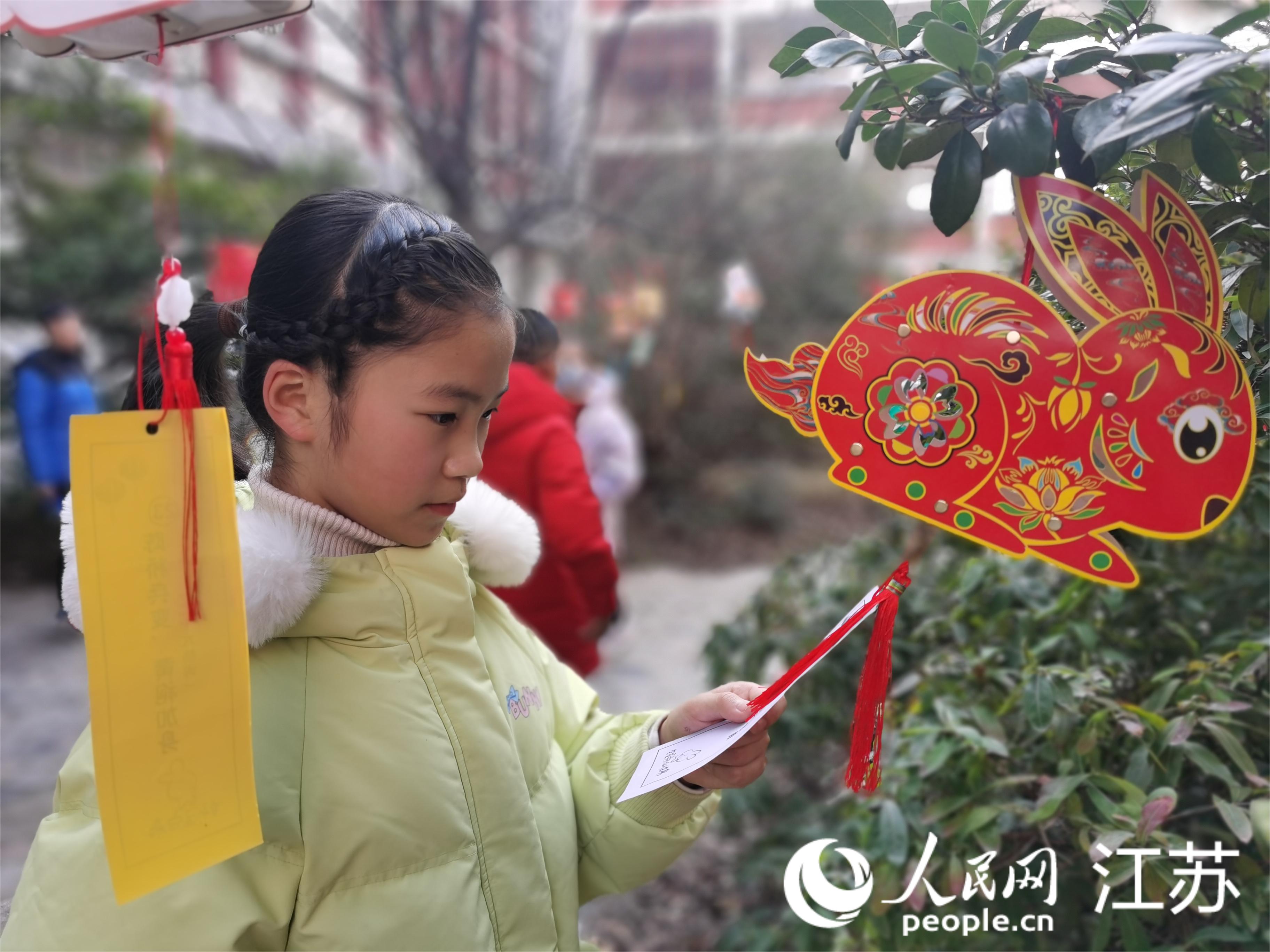 孩子们正在猜灯谜。人民网记者王继亮摄 