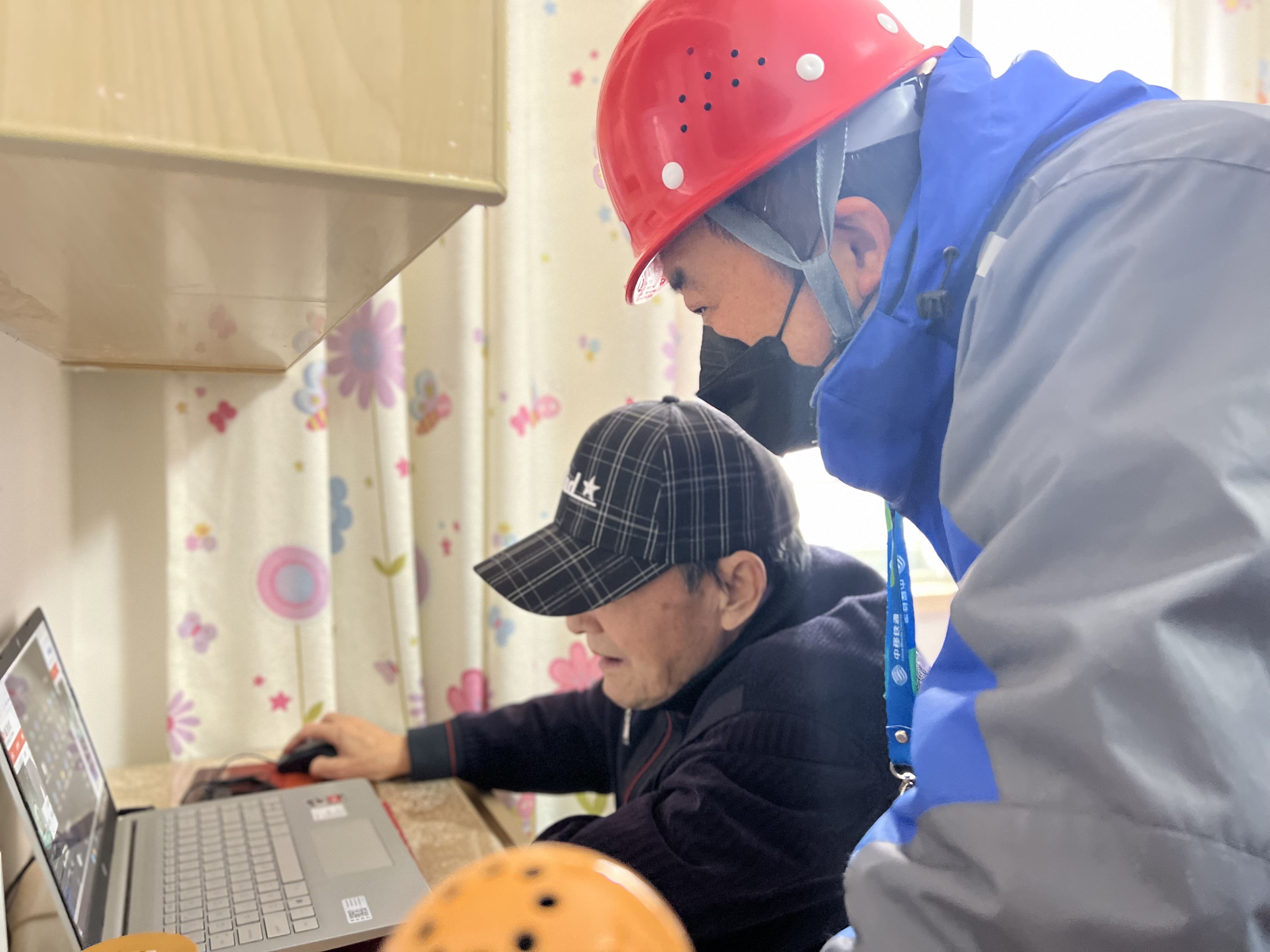 扬州移动装维师傅正在老年用户沈大爷家指导如何操作电脑观看体育赛事。江苏移动供图