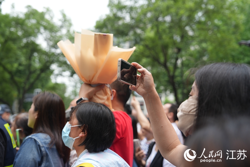 考生家长正在拍摄考生出考点的画面。人民网 李静晔摄