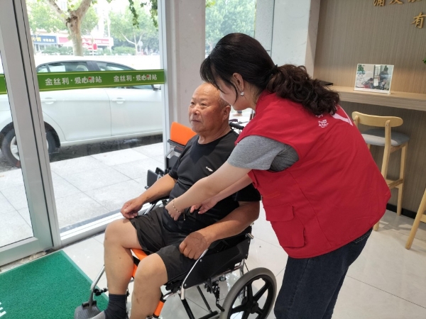 驿站志愿者为老人调试轮椅。宿迁烟草供图
