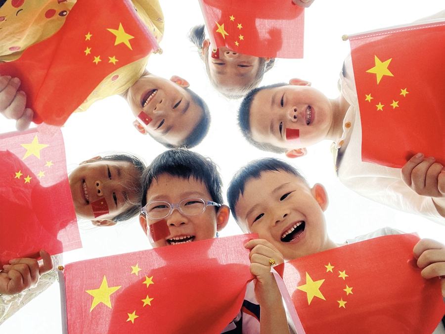 小朋友与国旗合影。王添烨摄