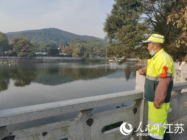 环卫工韩自锦目睹了东大池的生态变化。 人民网记者 张玉峰摄