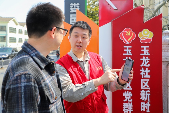 江苏省昆山市物业人员向居民介绍“昆物通”电子投票系统使用方法。昆山市住建局供图
