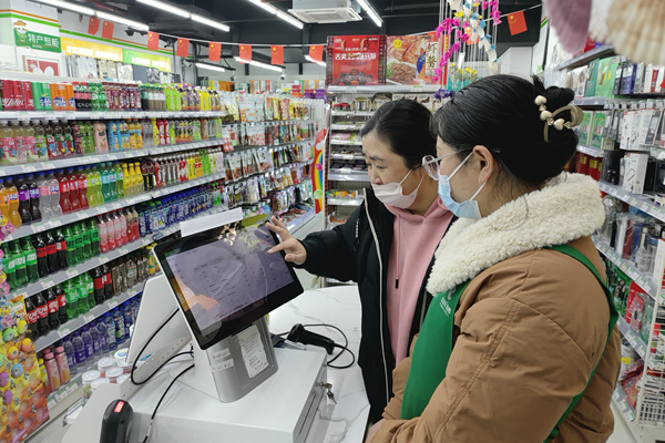 客户经理指导超市店员使用智能设备。连云港烟草供图
