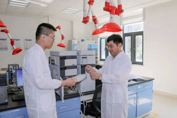 刘加平（右）在实验室与技术人员开展试验研究。江苏省住建厅供图