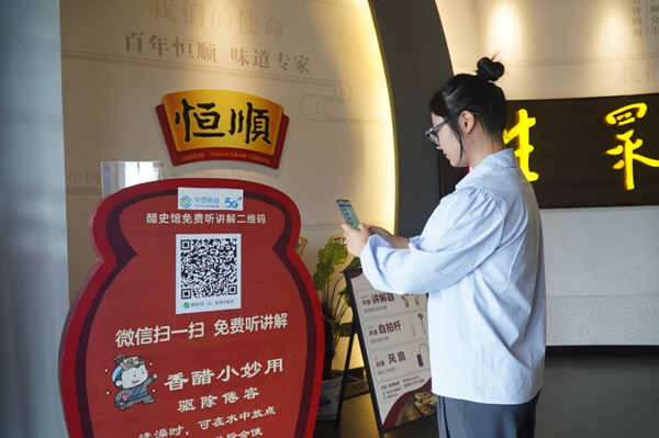 在镇江醋文化博物馆，游客扫描二维码收看5G人工智能讲解。江苏移动供图