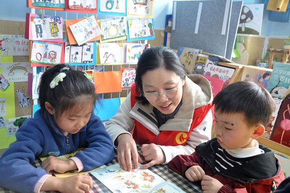 志愿者陪伴孩子们一起阅读。薛晓明摄 