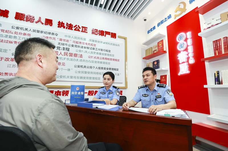 无锡办案民警向当事人通报案情。 殷正天摄