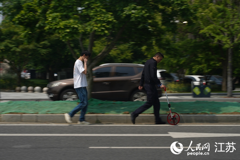 无锡交警根据“听我一言”群众意见测算道路改造位置。 人民网 郜超摄