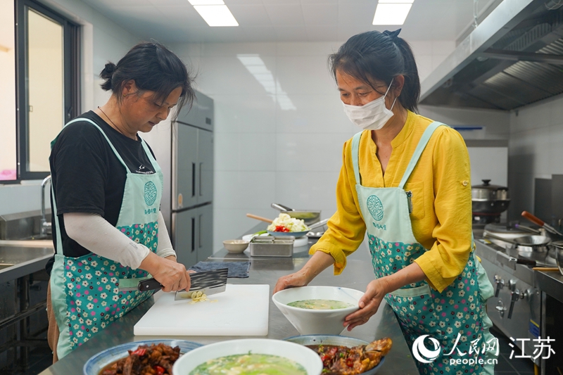 姜下村民宿厨房内，村民正在制作本地美食。人民网 郜超摄