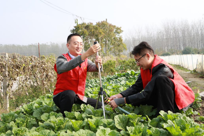 志愿者帮助村民安装自动灌溉设备