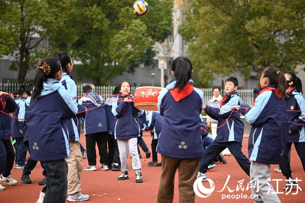 无锡市新吴区江溪小学学生课间在操场上一起玩同心鼓。 人民网 鞠峰摄