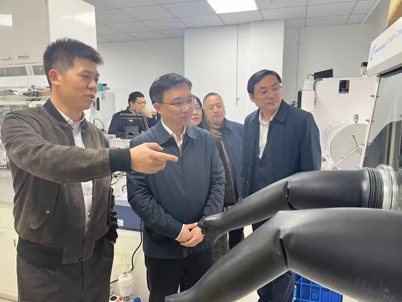 王飞（左）向来宾介绍介绍企业研发情况。受访者供图