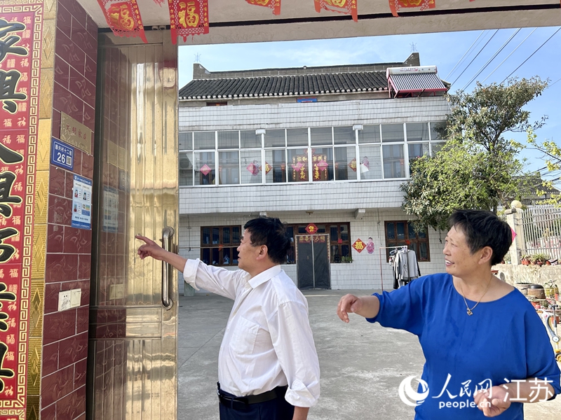 杨呈高老两口展示自家“文明家庭”标牌。人民网 王丹丹摄
