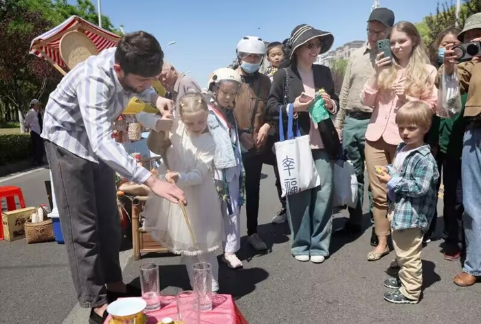 中外友人体验非遗技艺。崇川区幸福街道供图