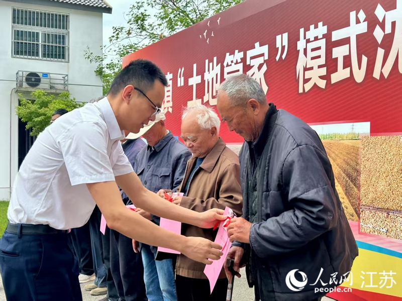 向村民发放土地保底收入和农村基本医疗保险费用。人民网 王丹丹摄