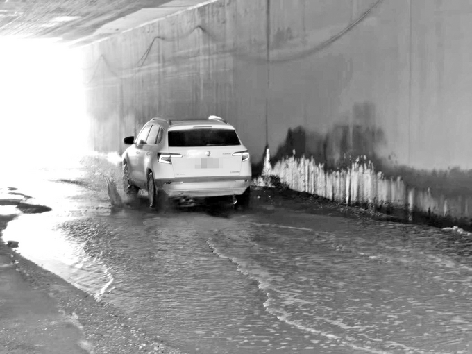 涵洞內，機動車經過濺起的水漬在牆壁上清晰可見。