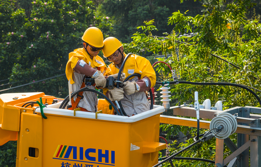 电力工人进行新建线路引线带电搭接作业。刘列摄