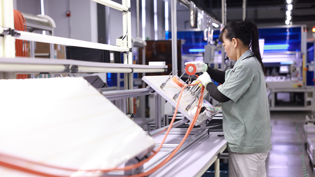 昆山沪光汽车电器股份有限公司，工人正在生产汽车线束。人民网 余乐摄