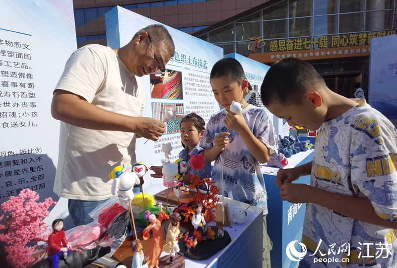 南通面塑非遗代表性传承人罗彬与孩子们互动。人民网记者 王继亮摄