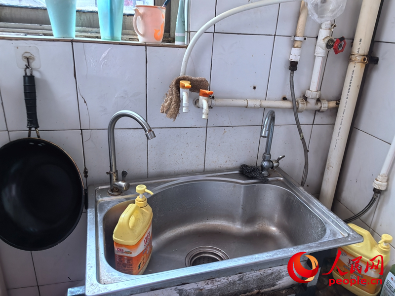 7月17日居民张桂芬家厨房，加装3个水龙头的洗碗池。 人民网 商帆摄
