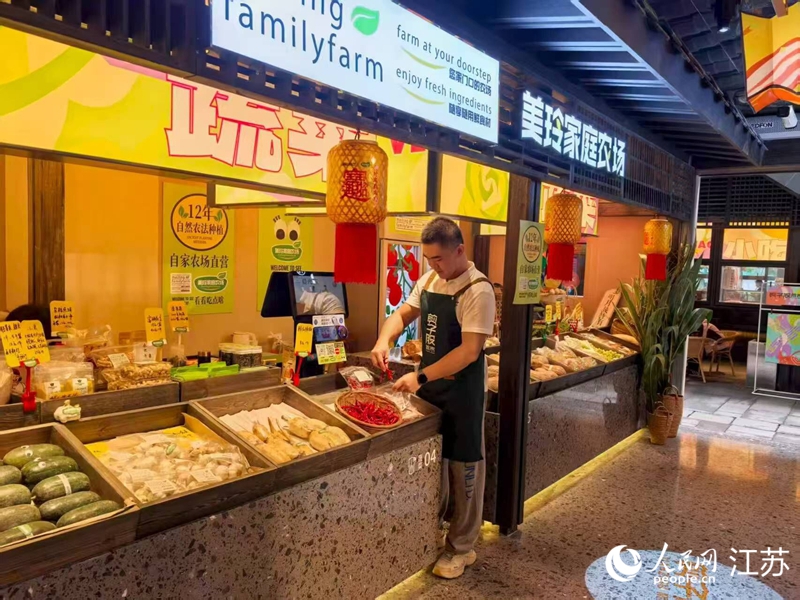 孙放在剪子股菜市里的摊位,经营自家农场的蔬果。人民网 李欣阳摄