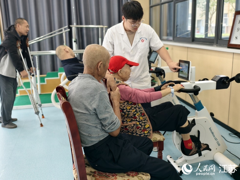 康复治疗师沈阳正在协助老人做康复训练。人民网记者 马晓波摄