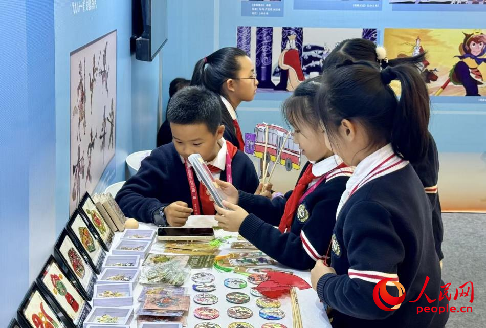 小朋友在观看皮影作品。人民网 记者杨睿摄