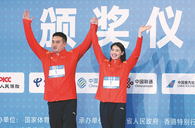 张雨霏领奖前与教练一同庆祝比赛夺冠。 本报记者 万程鹏 摄