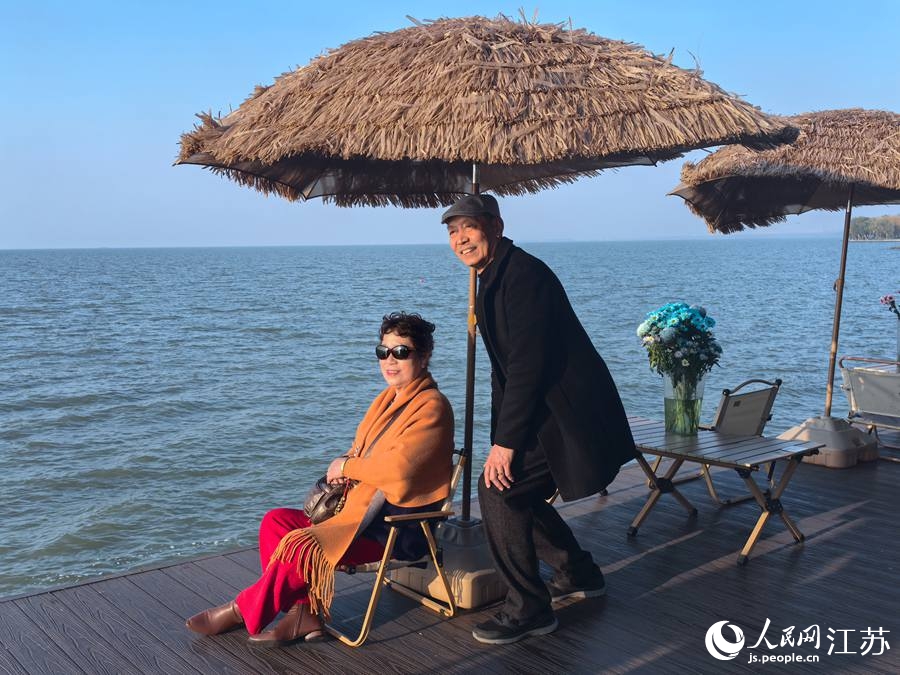 游客在洪泽湖旅游公路打卡点拍照留念。人民网 崔小倩摄