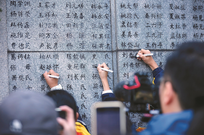 11月30日，南京大屠杀幸存者、南京大屠杀历史记忆传承人、南京大屠杀遇难同胞遗属、青少年及志愿者代表等，聚集在南京大屠杀遇难者名单墙（又称“哭墙”）前，一同祭奠在大屠杀中惨遭杀害的无辜同胞。 本报记者 万程鹏 陈俨 摄