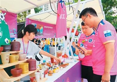 “苏超”镇江球迷购买“非遗”文创产品。  江苏省文化和旅游厅供图