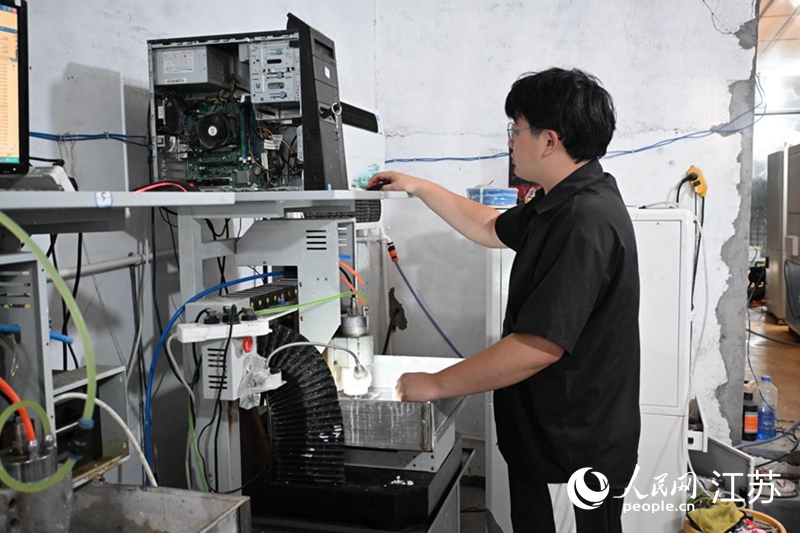 本地年轻从业者使用雕刻机械进行玉石设计。人民网记者张瀚天摄