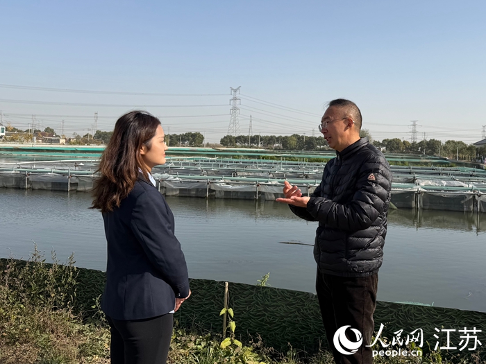 泰兴邮储客户经理（左）走访螃蟹养殖户。 人民网 任晓燃摄