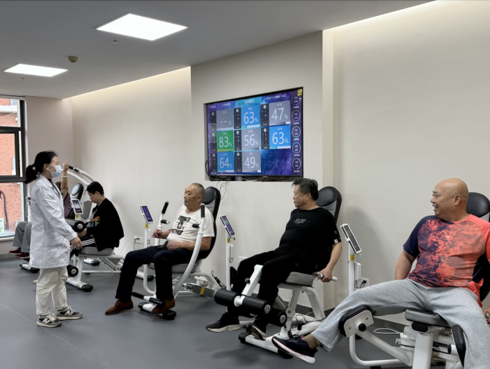运动处方师指导患者锻炼，大屏实时显示数据。南京幕府山社区医院供图