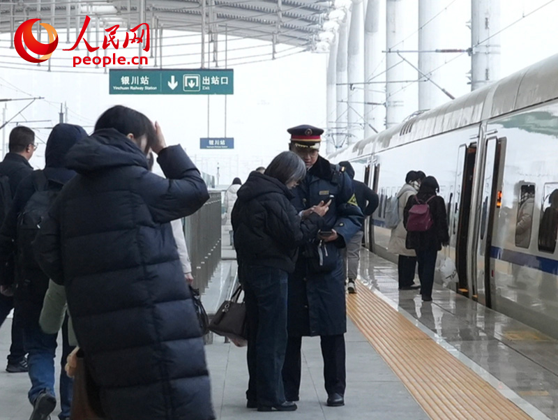 1月4日，银川火车站工作人员正在帮助旅客核对乘车信息。人民网记者 梁宏鑫摄
